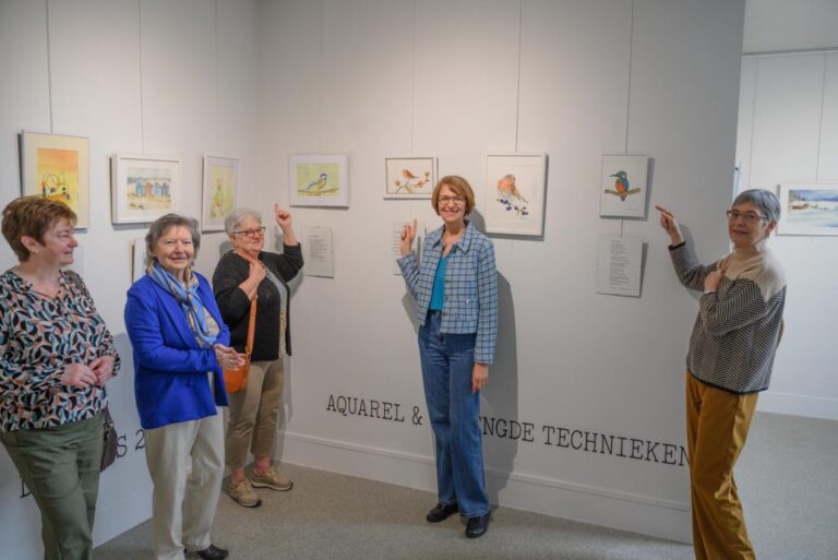 Denise De Lille met haar cursisten bij de aquarellen en de gedichten. © GVA Erik Van Eycken