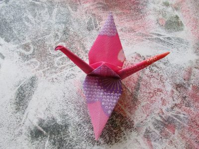 Origami "De Kraanvogel" in combinatie met schilderkunst, dichtbundel “Resonantie” blz. 53  © Kavita Vlieghe & Denise De Lille